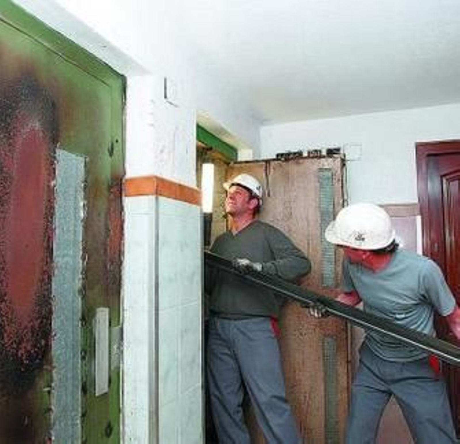 Dos operarios arreglan el ascensor, ayer.