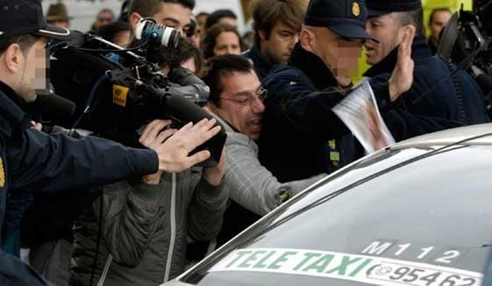 Un grupo de personas congregadas a las puertas de los Juzhados increpan el taxi donde llega uno de los imputados.

Foto: Manuel Gómez