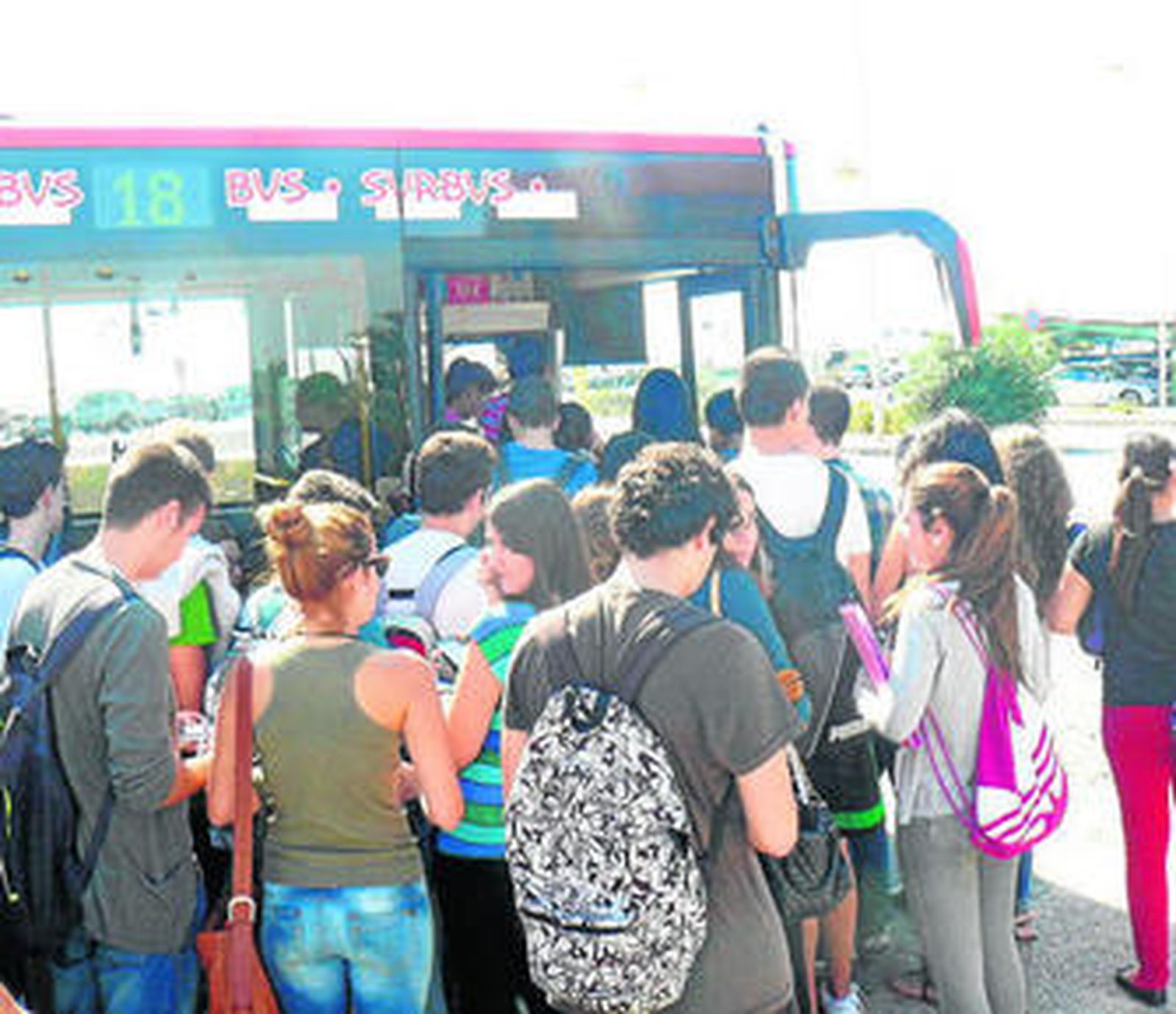Estudiantes de la Universidad guardan cola para subir al autobús.