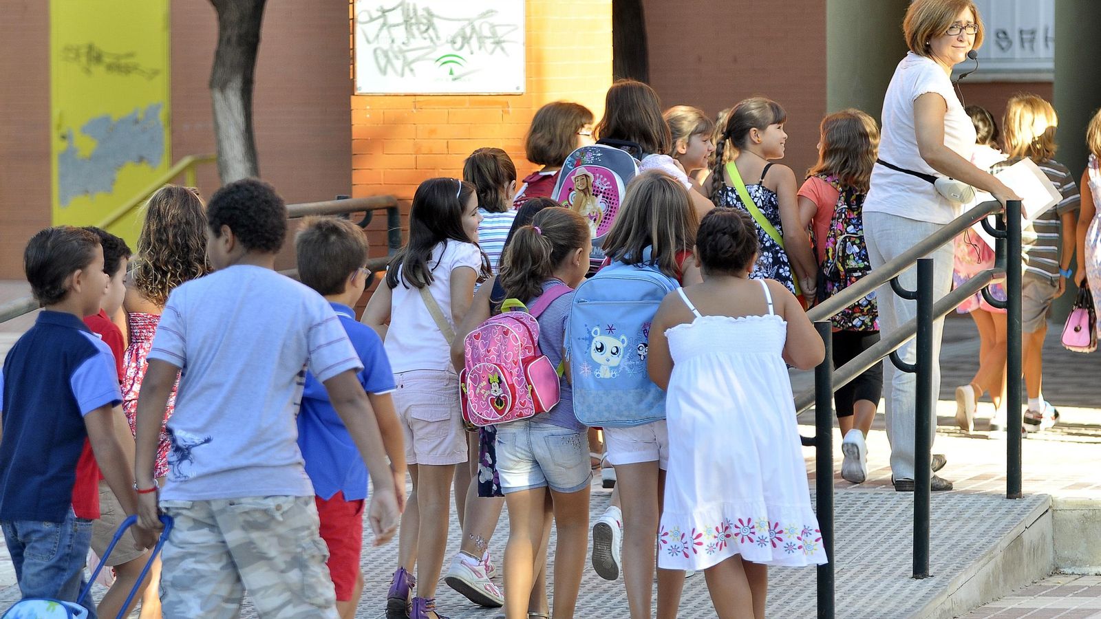 Niños entrando en un colegio el primer día de clase.