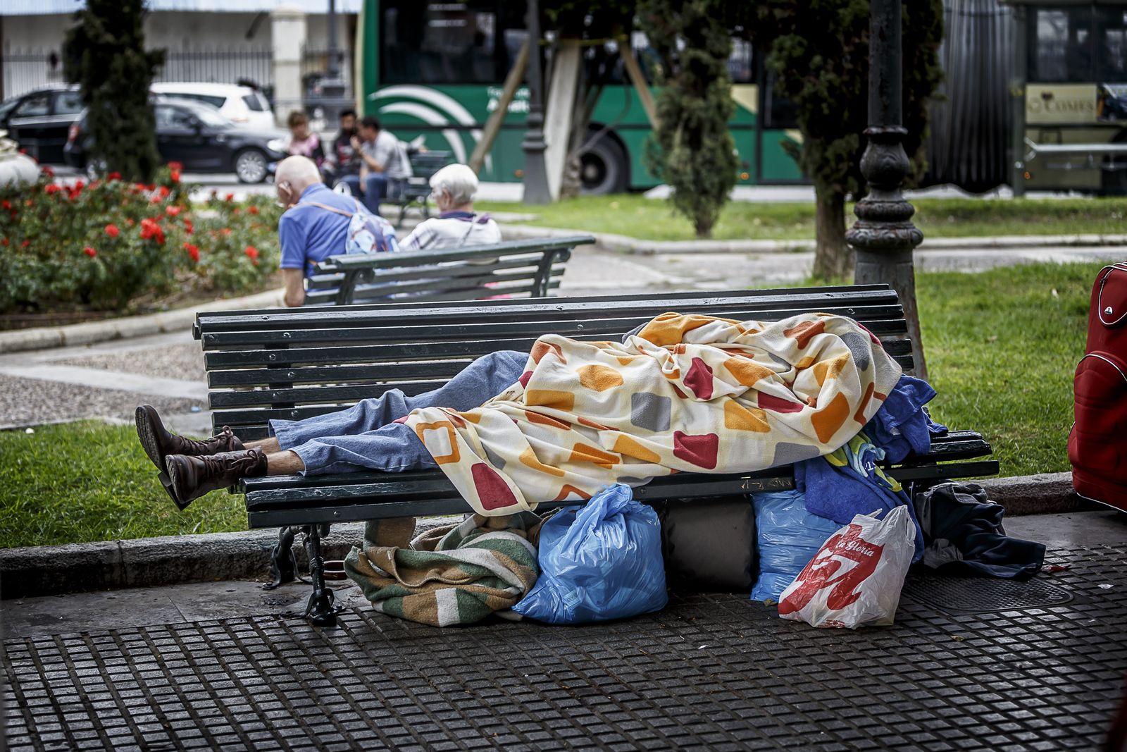 Uno de los sin techo duerme en un banco en la capital gaditana.
