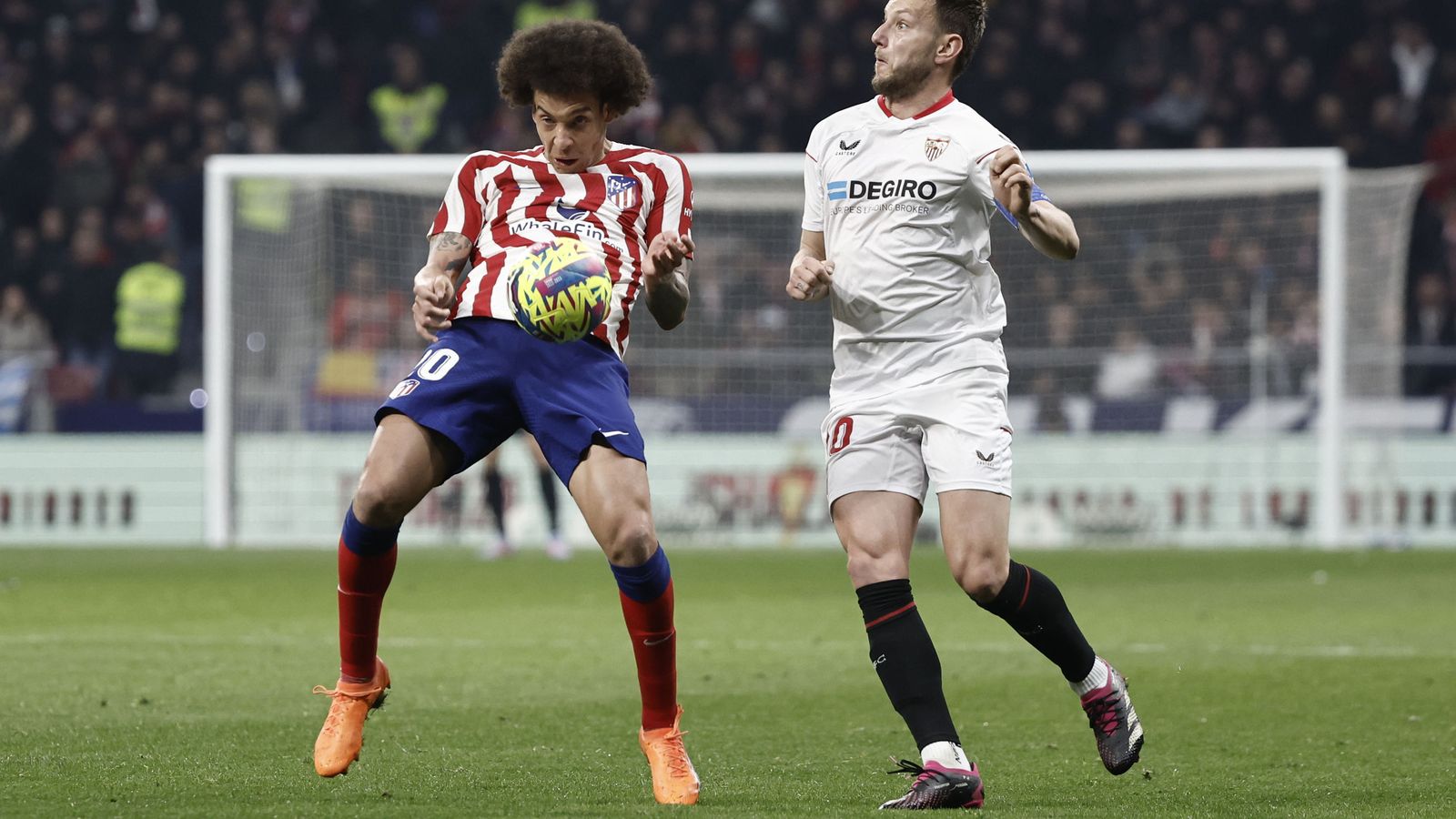 Rakitic busca un balón arrugado ante Witsel.