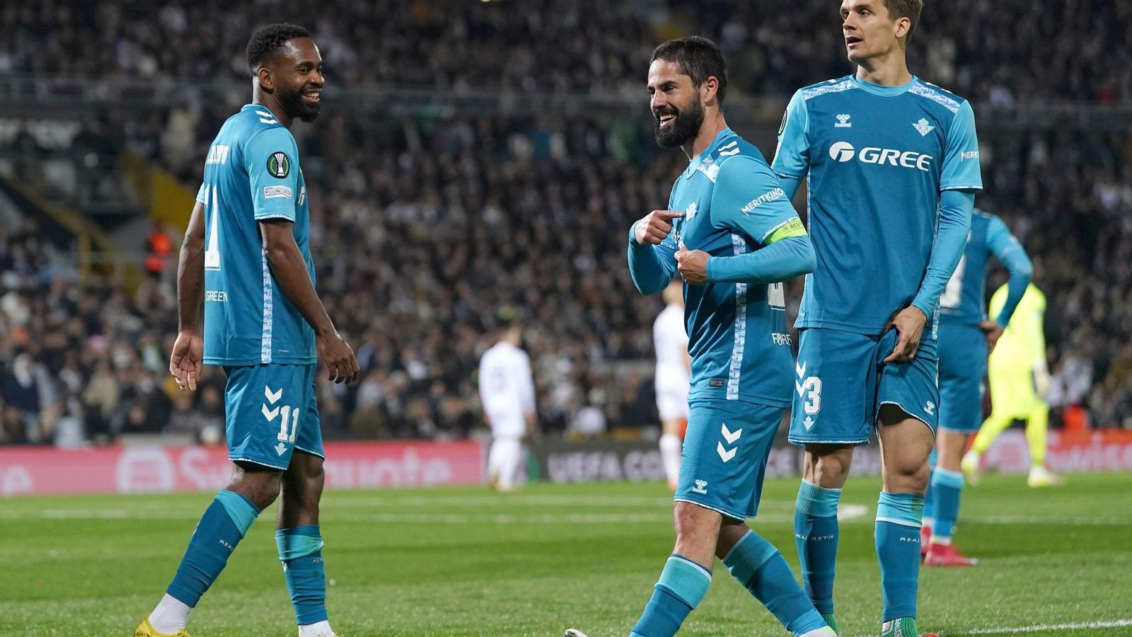 Isco celebra su gol, junto a Bakambu y Llorente, señalando el escudo del Betis.