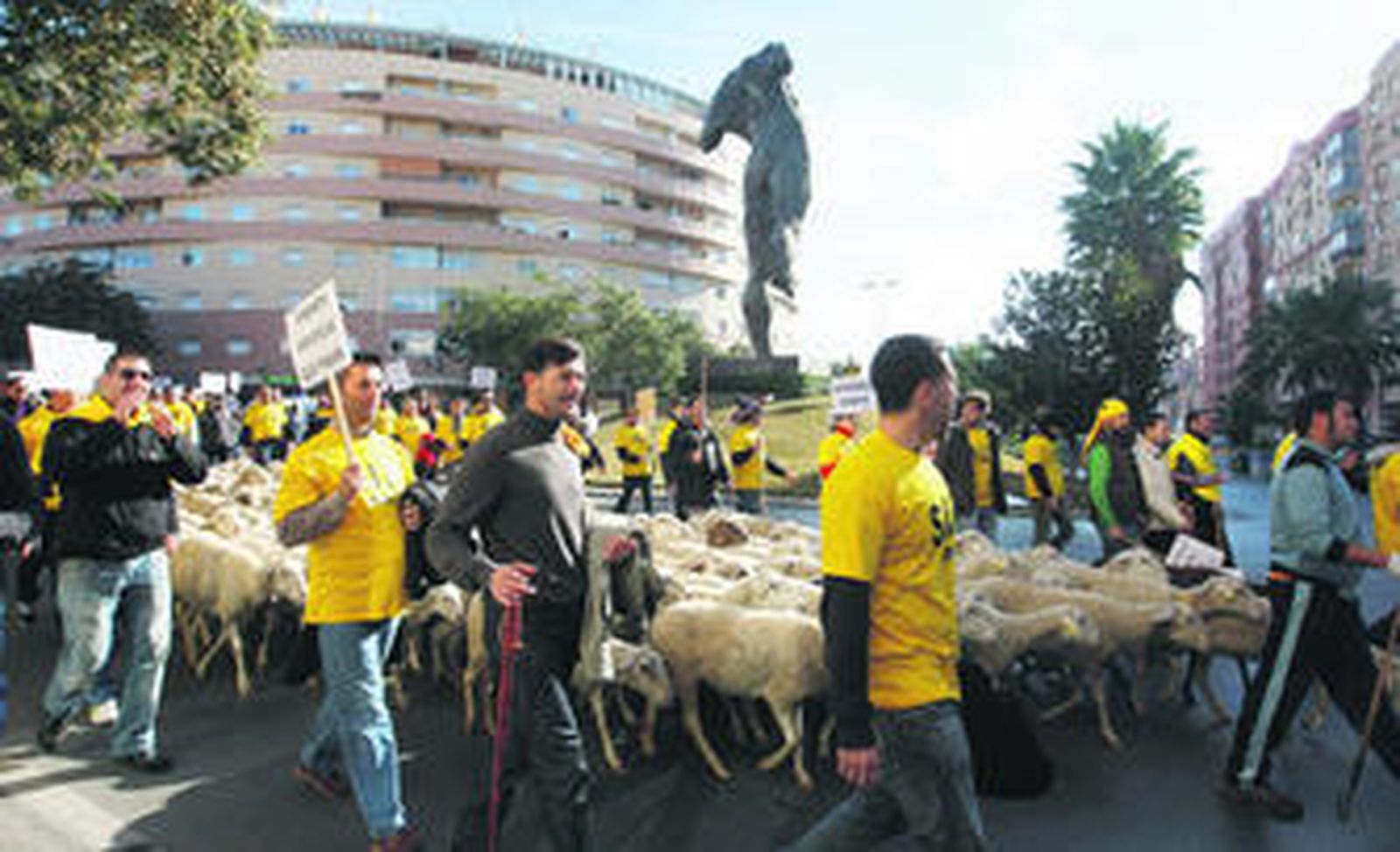 Los policías locales conducen al rebaño de ovejas ayer por la rotonda del Minotauro.