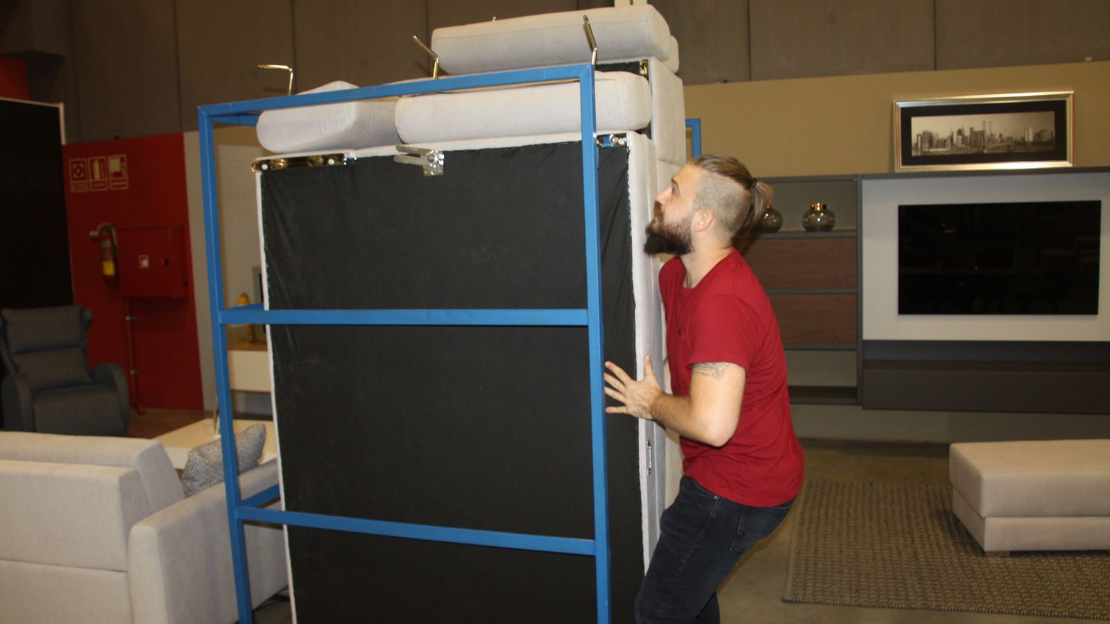 Un trabajador de Romero Hogar, en El Ejido, acarreando un sofá