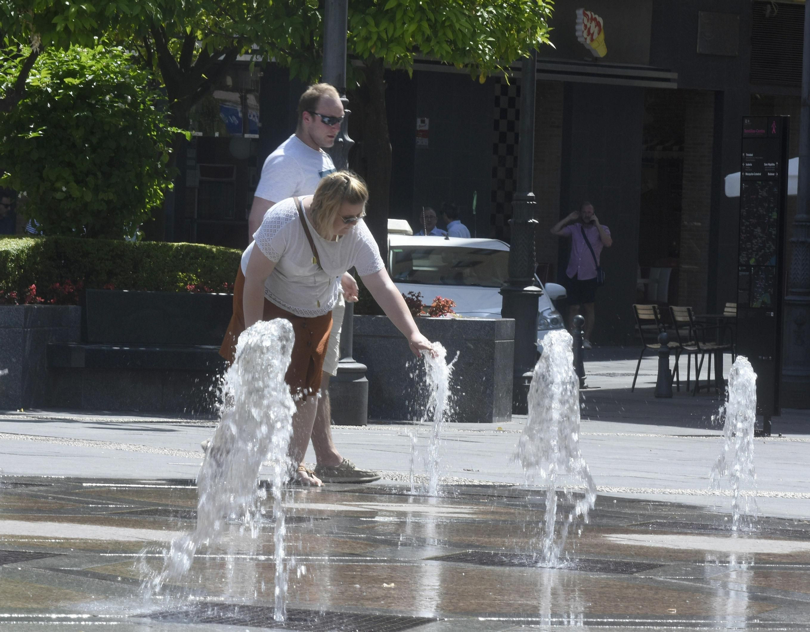 Personas refrescándose en la plaza de Tendillas.