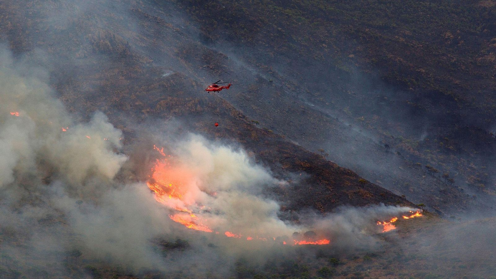 Un helicóptero en las tareas de extinción del fuego en Sierra Bermeja. Un helicóptero en las tareas de extinción del fuego en Sierra Bermeja.
