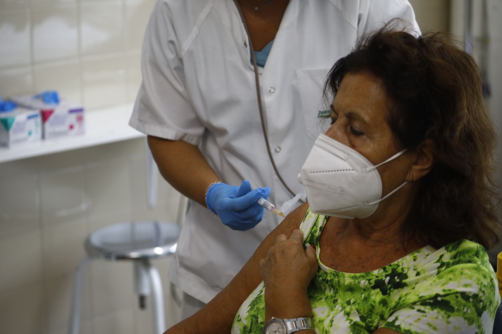 Una mujer recibe la inyección de la gripe.