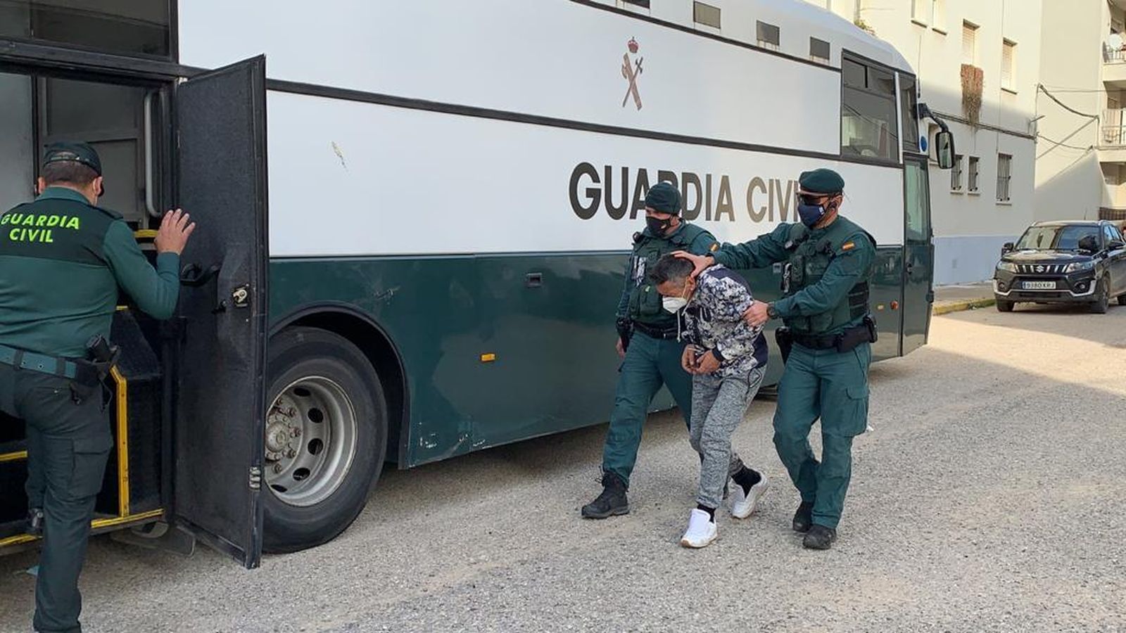 Uno de los detenidos siendo conducido hasta el furgón de la Guardia Civil.
