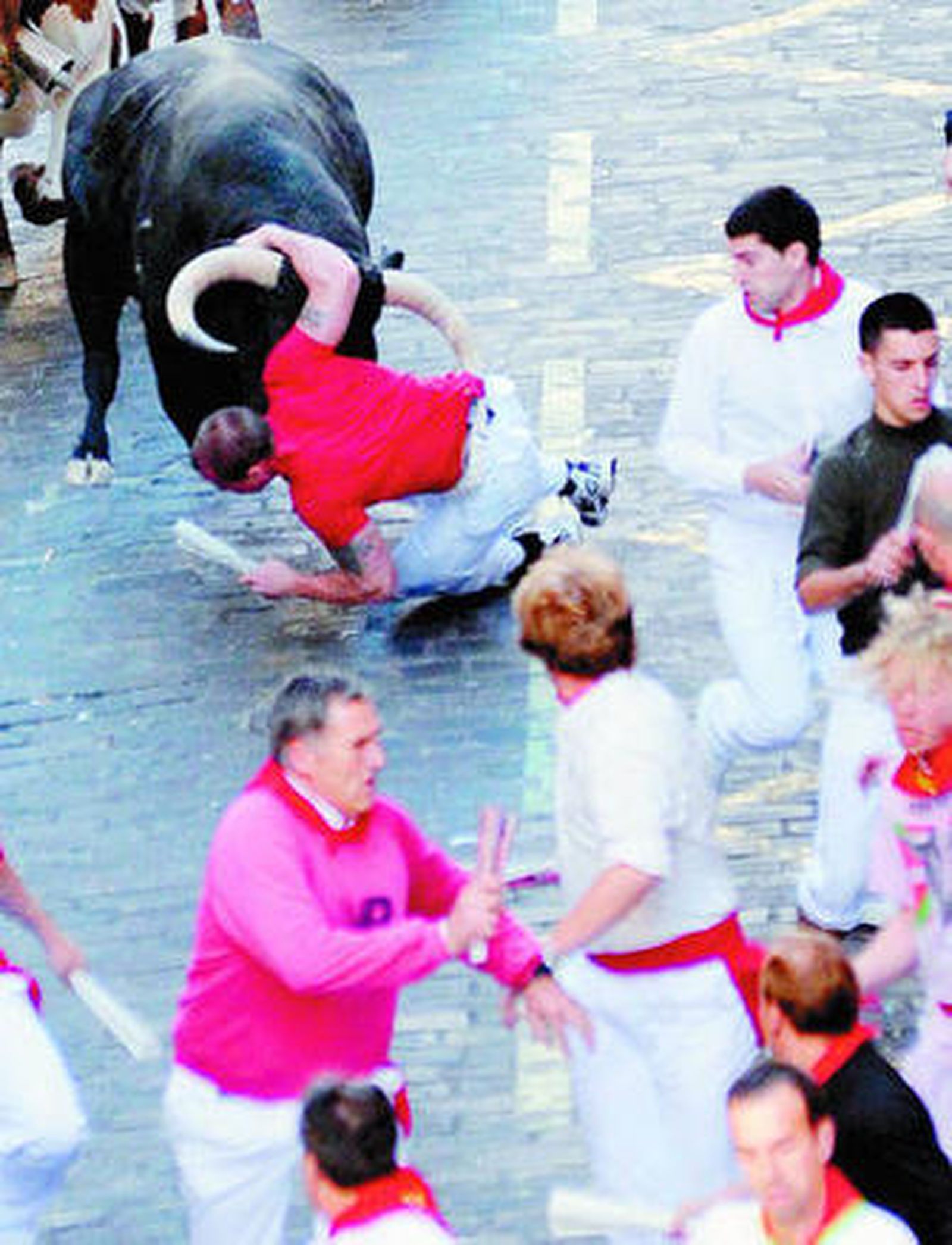 Un toro arrollando a un mozo en la cuesta de Santo Domingo.