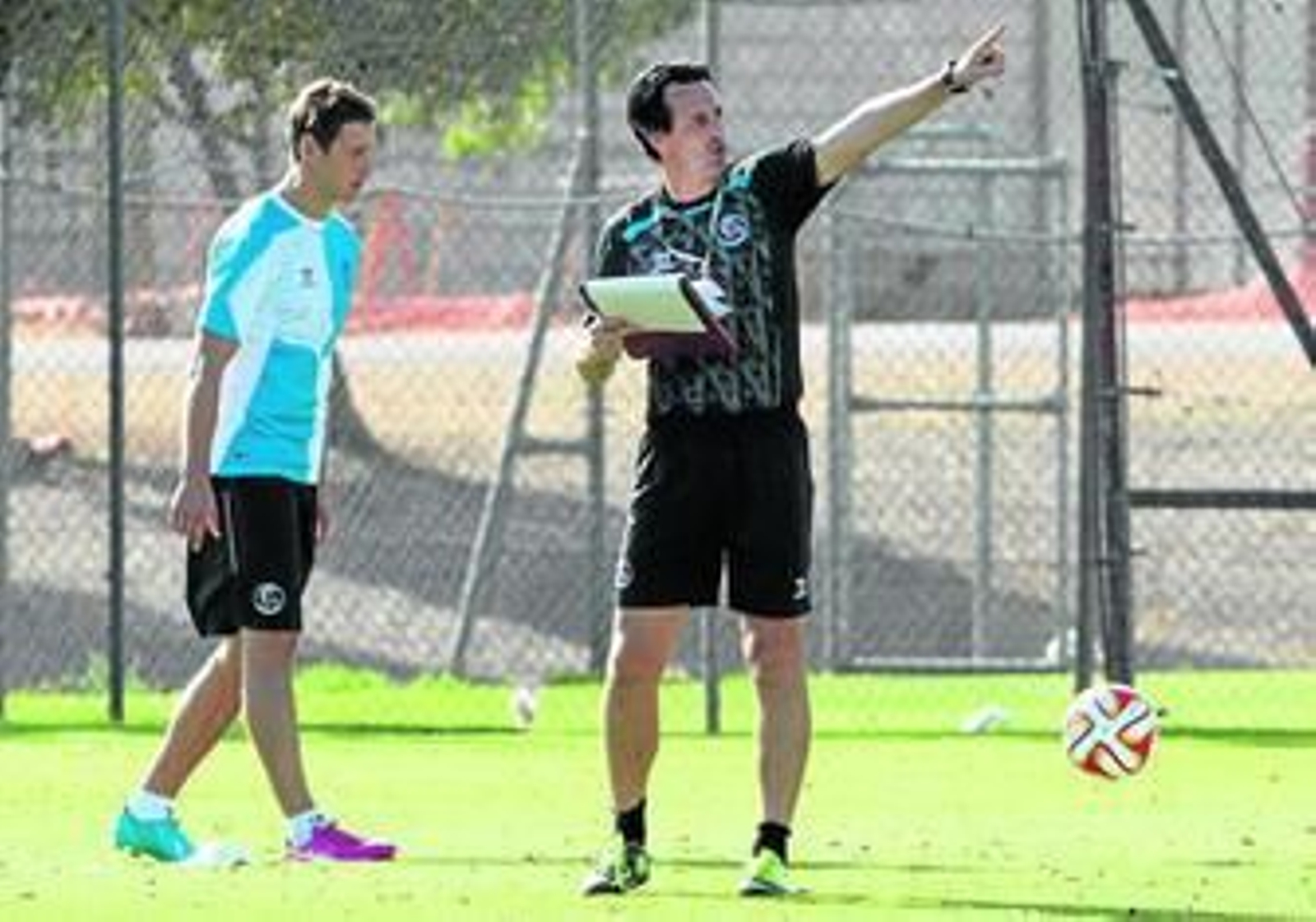 Unai Emery organiza la sesión de entrenamiento con el mediocampista polaco Krychowiak a la espalda.