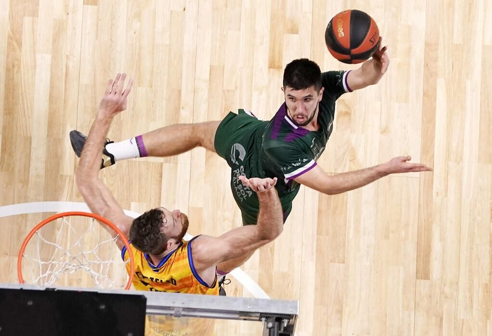 Axel Bouteille lanza a canasta en posición acrobática.