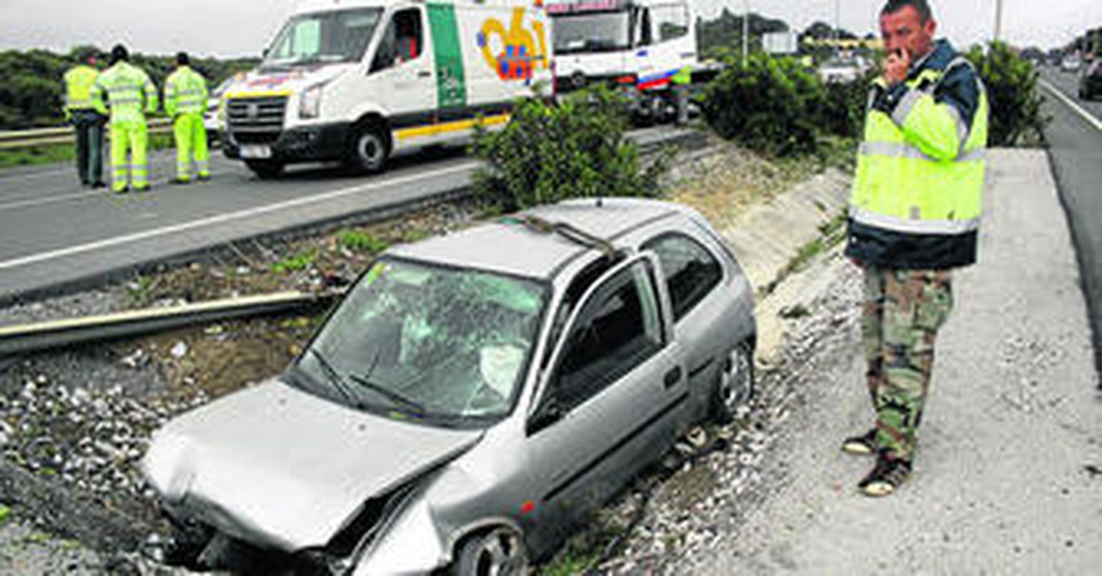 Un operario de grúas prepara el turismo siniestrado para ser retirado de la mediana.