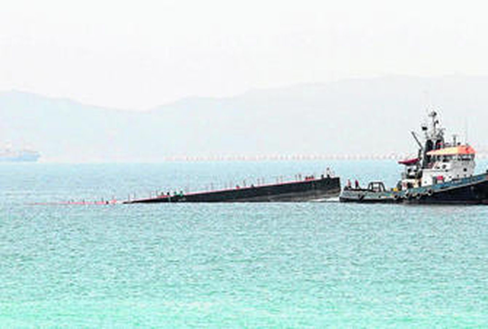 Imagen de la pontona semihundida poco antes de que comenzaran las labores de achique de agua, ayer.