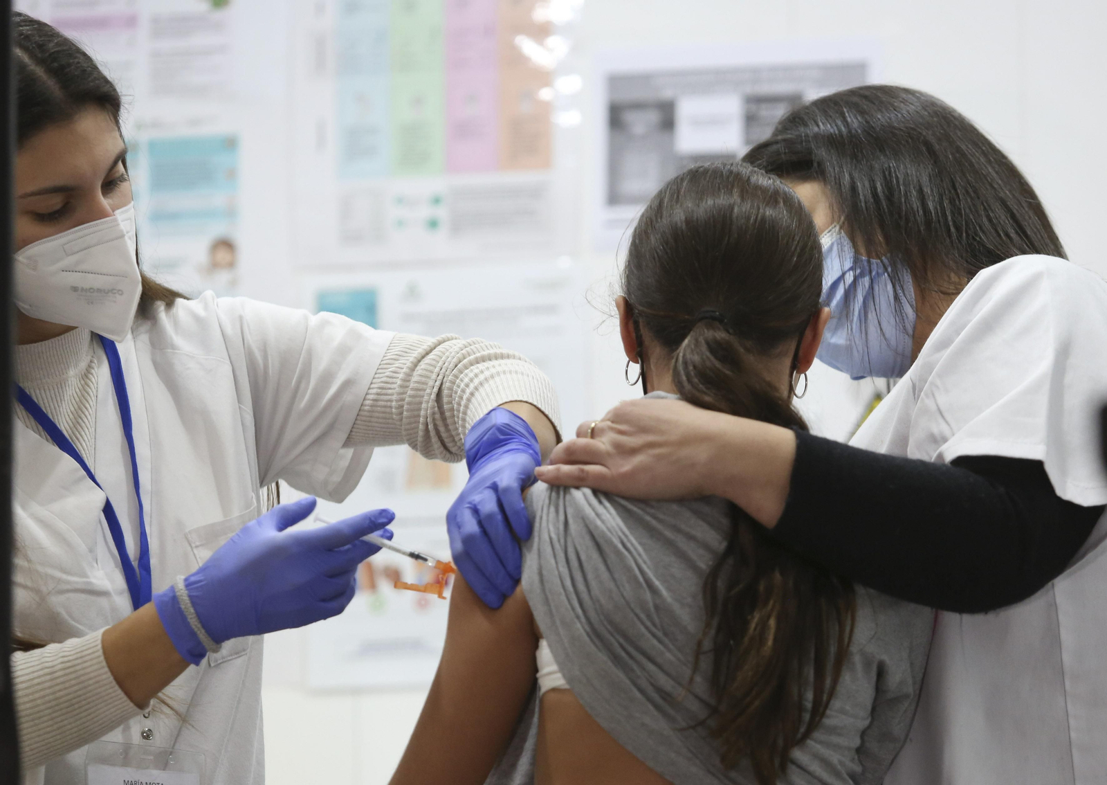 Una enfermera vacuna a una niña en la unidad móvil de El Palo.