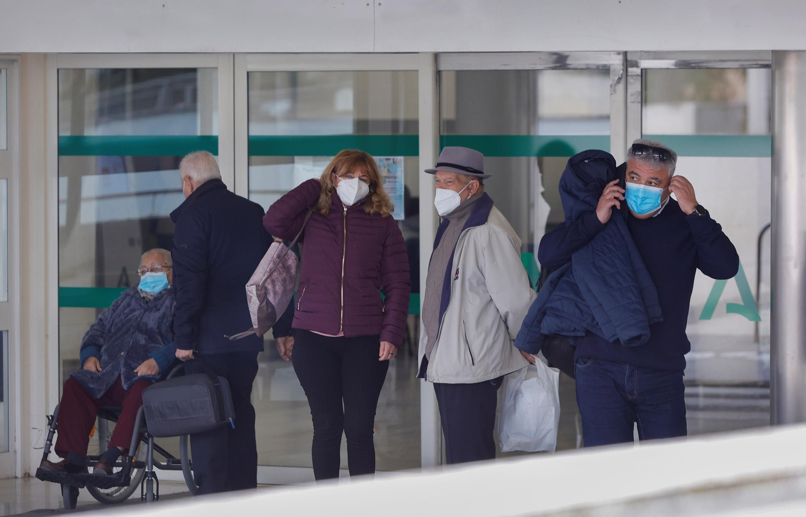 Varias personas acceden a un centro de salud con mascarilla.