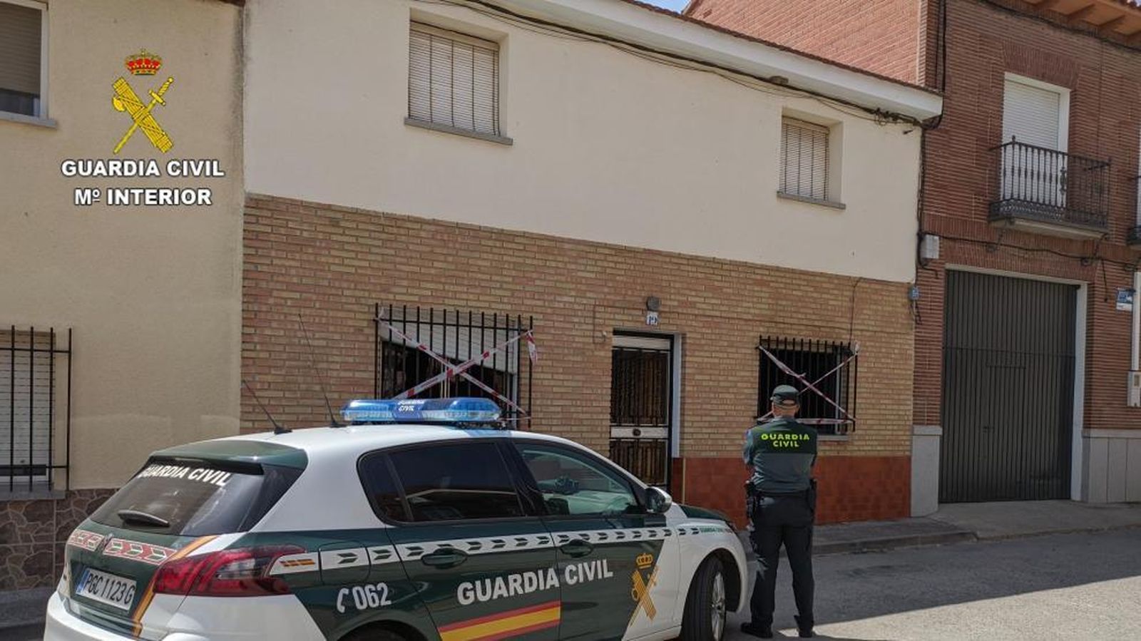 Un agente ante una casa incendiada por culpa de un brasero.