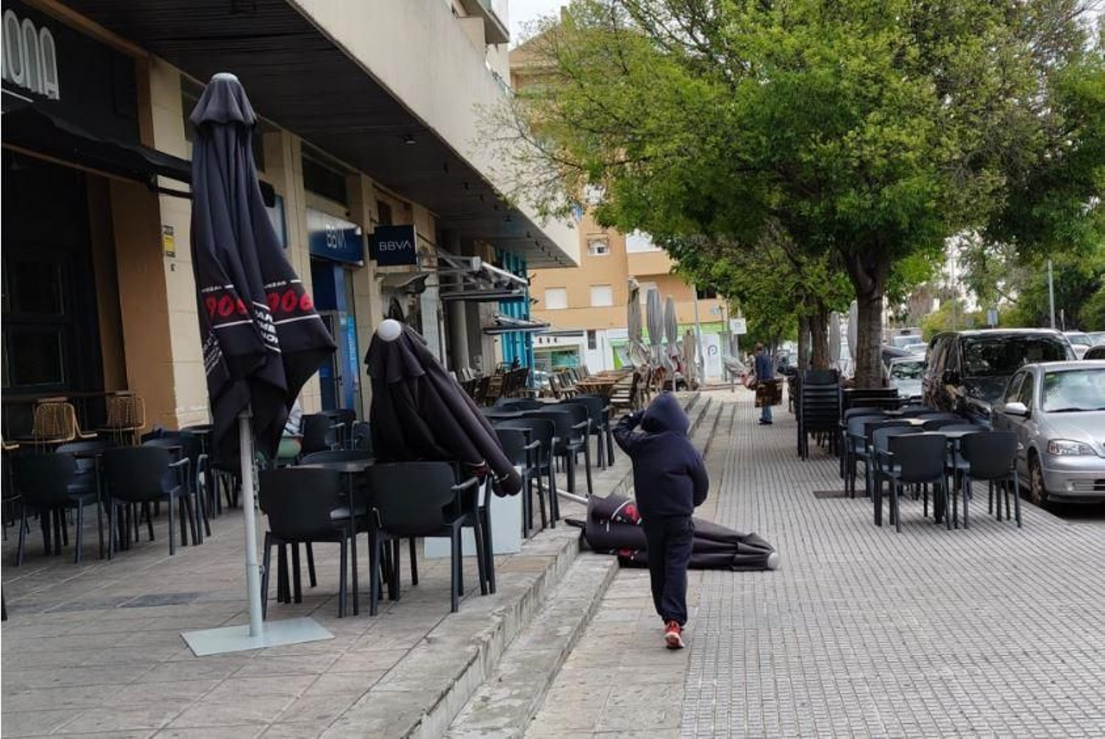Sombrillas de bares tiradas en el suelo por el fuerte viento, este viernes por la mañana.