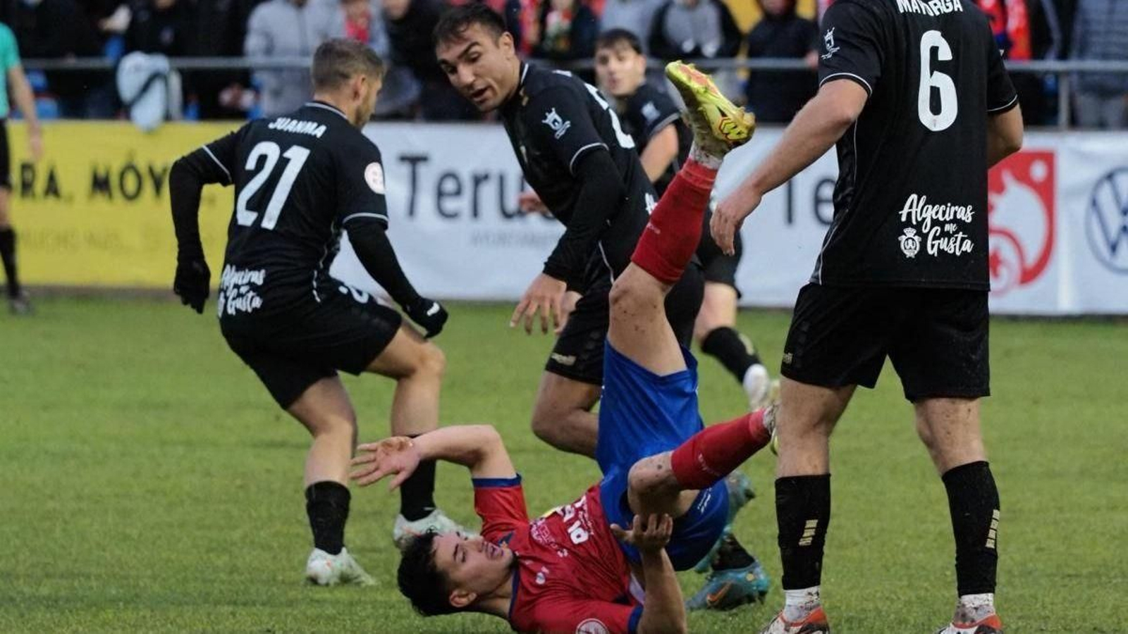 Óscar Castro y Juanma, ante un jugador del Teruel sobre el césped.
