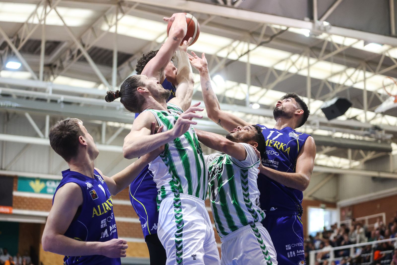 Los béticos Berzins y Polanco buscan el rebote ante varios jugadores del Alimerka Oviedo.