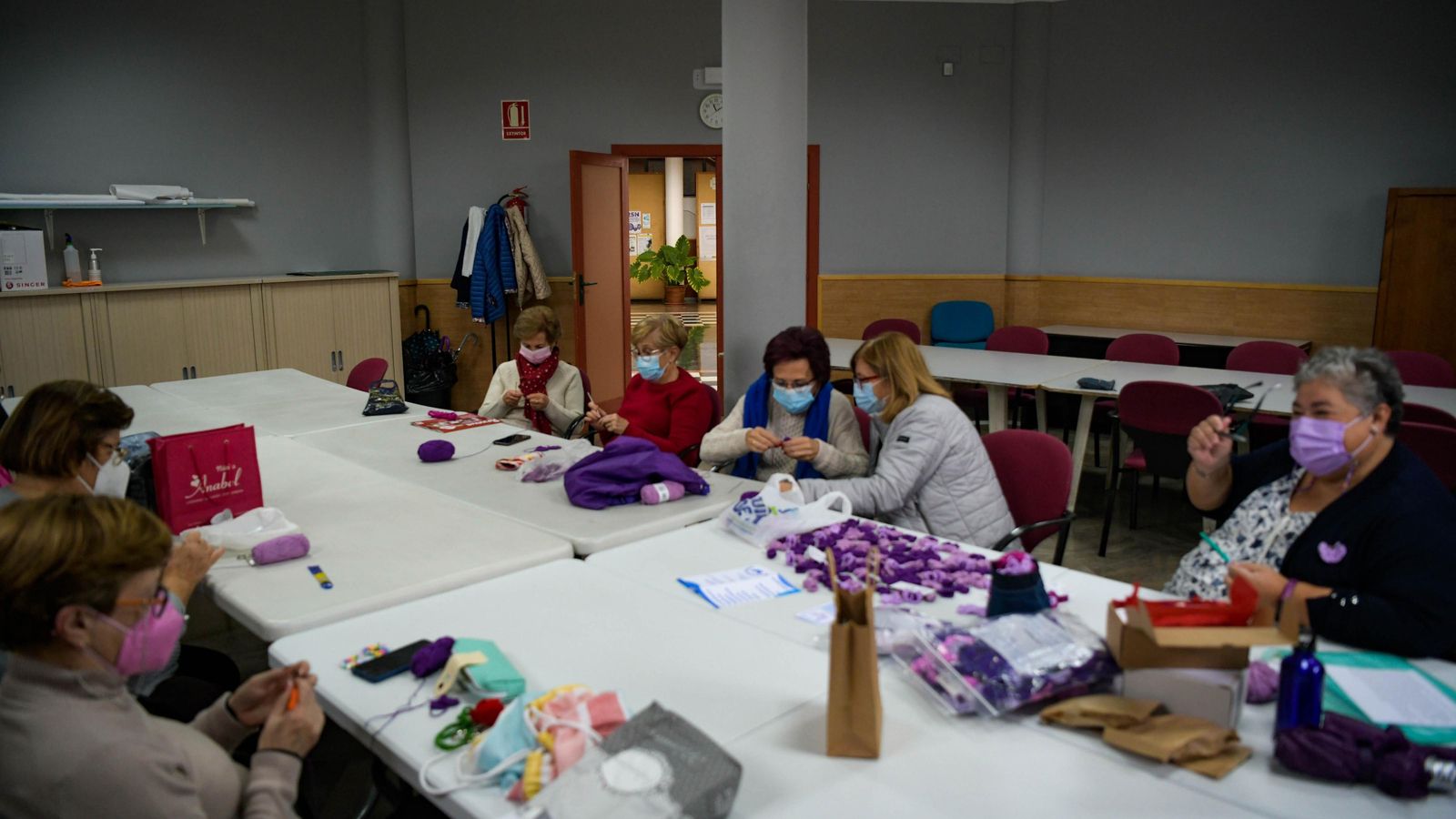 Algunas de las mujeres de AMEFA, tejiendo las mariposas moradas.