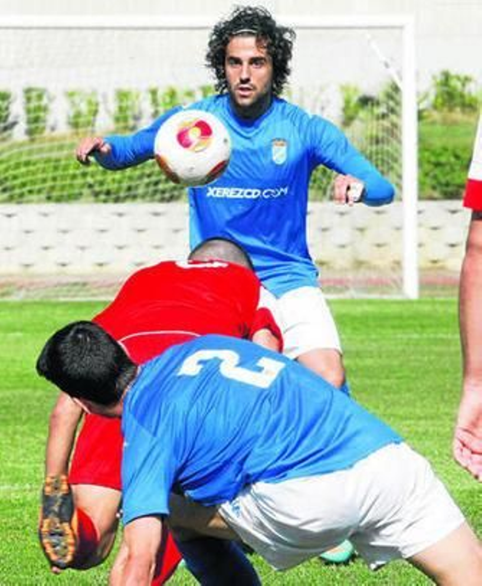 Toni Seoane controla el balón mientras Dani Albacete cae al suelo junto a un adversario.