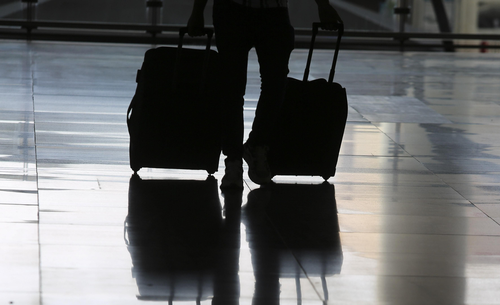 Un turista arrastra dos maletas.