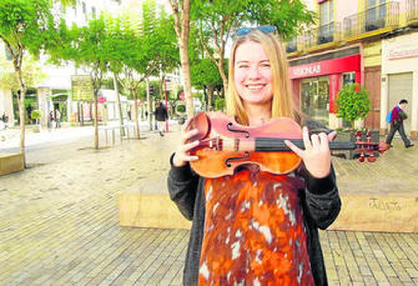 Lara St. John, una de las grandes virtuosas del violín, ayer al mediodía en la Puerta de Purchena junto al instrumento que toca que data de 1779.