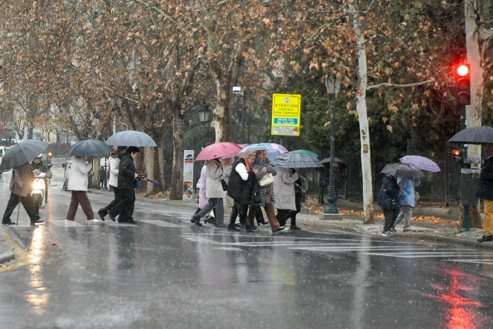 Viandantes en Granada mientras se desarrolla la borrasca Karlotta