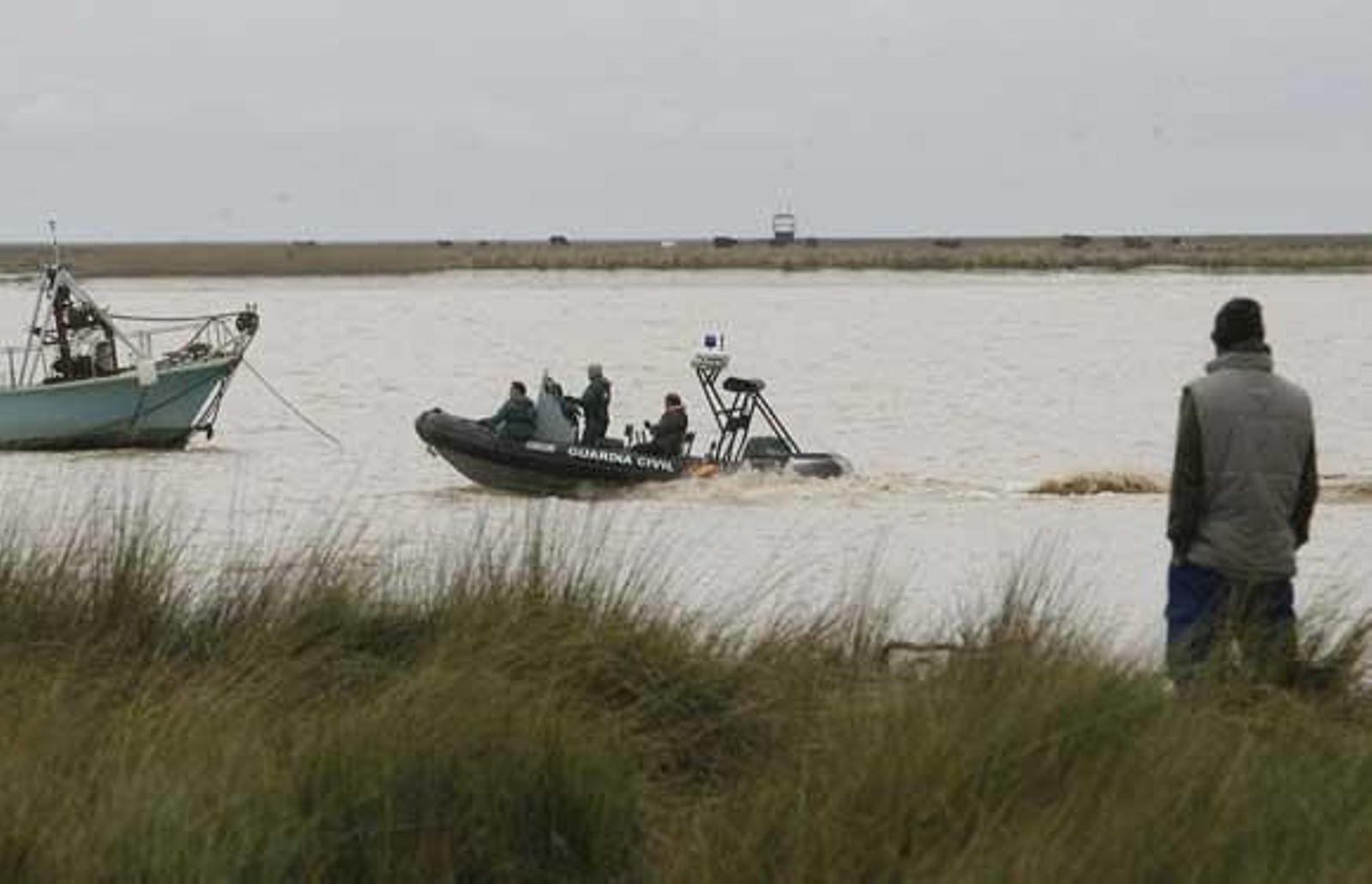 Un riachero observa una lancha de la Guardia Civil.

Foto: Borja Benjumeda