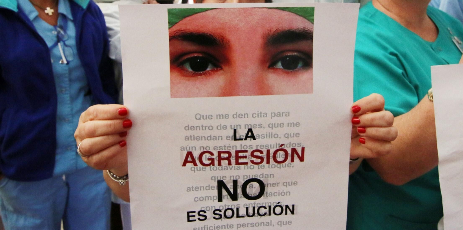 Una profesional sujeta un cartel contra las agresiones a sanitarios.