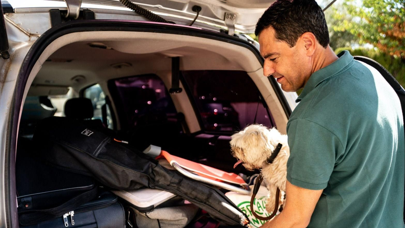 El presidente de la Junta, Juanma Moreno, sostiene a su mascota en el verano de 2022.