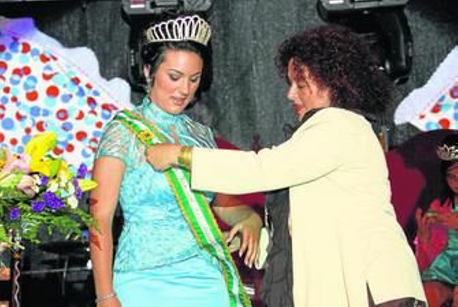 La alcaldesa de Los Barrios, Ángeles Ariza, coloca la banda de honor a la reina juvenil, Macarena Ortega, tras colocarle la corona, anoche.