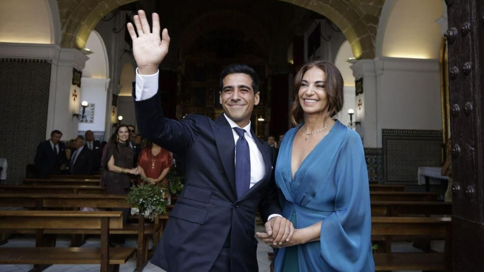 Alberto Herrera, el novio, y la madrina, Mariló Montero, saludan en la puerta de la basílica de la Patrona de Sanlúcar de Barrameda