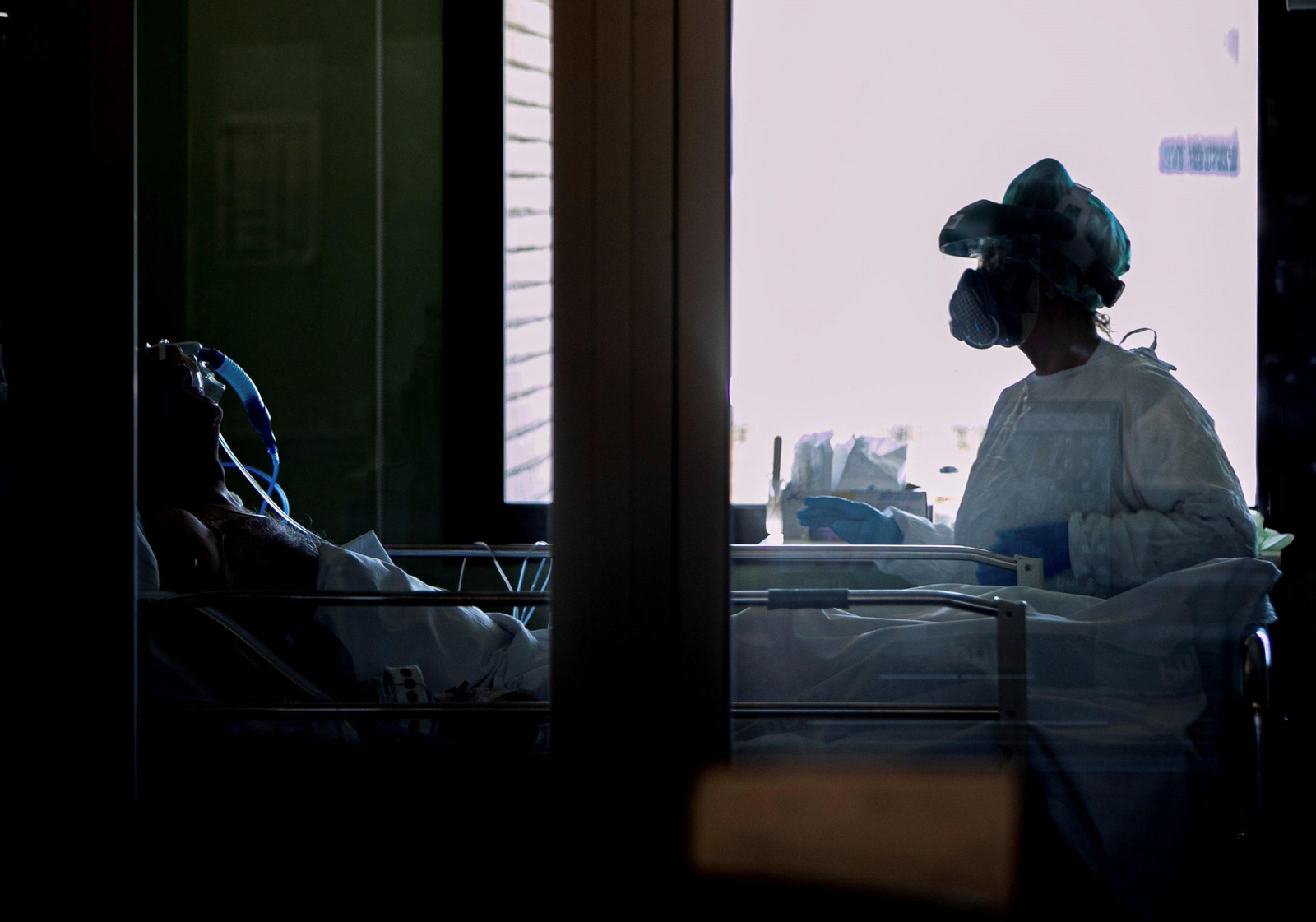 Una sanitaria se prepara para tratar a un paciente con covid.