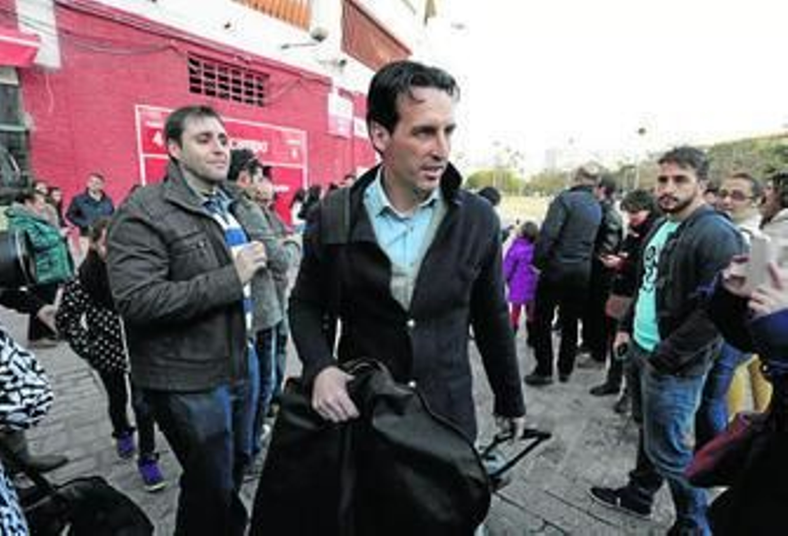 Unai Emery, rodeado de aficionados, antes de partir ayer hacia el aeropuerto con destino Madrid.