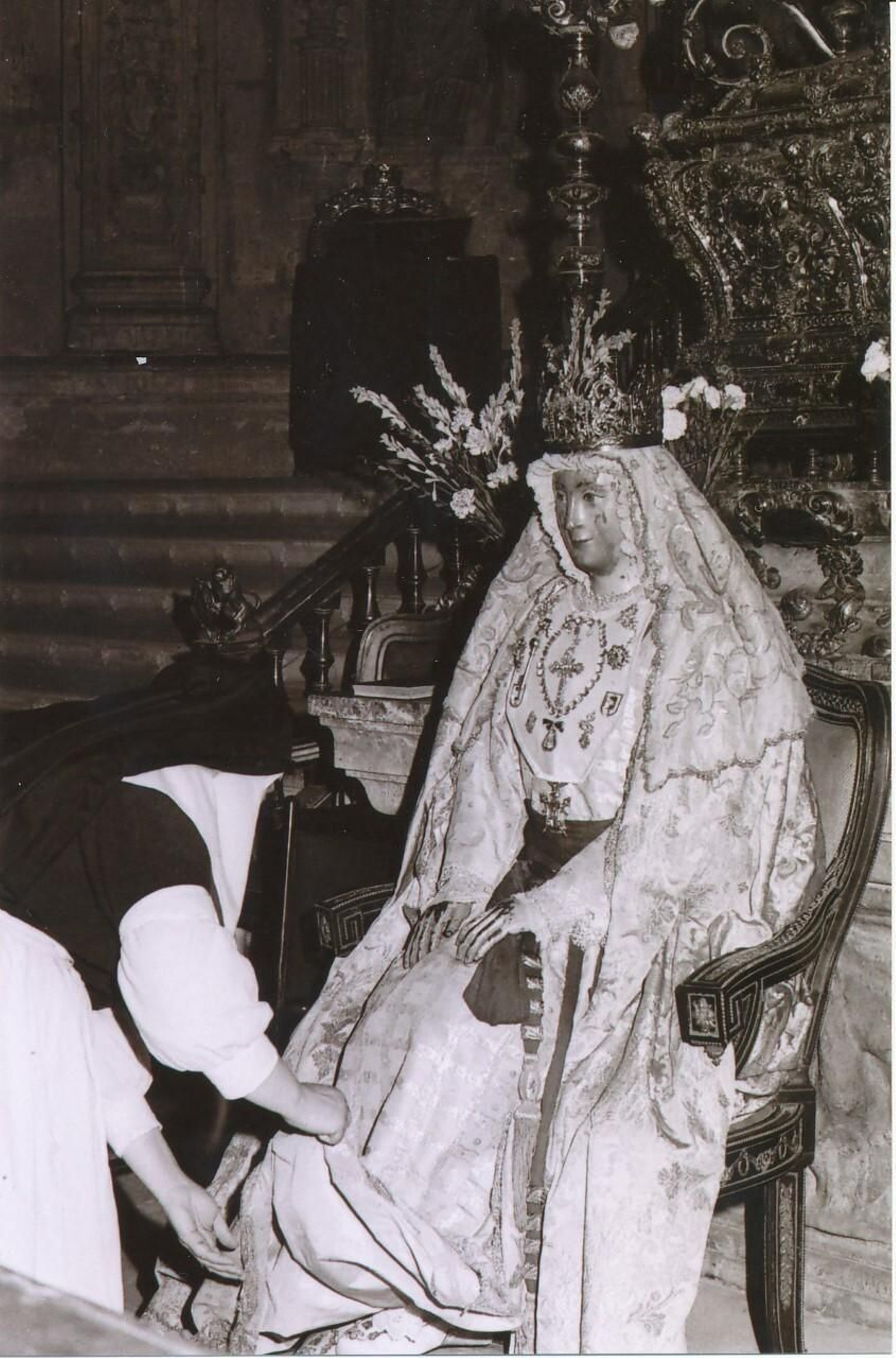 Una hermana de la Cruz viste a la Virgen de los Reyes para su besamano.