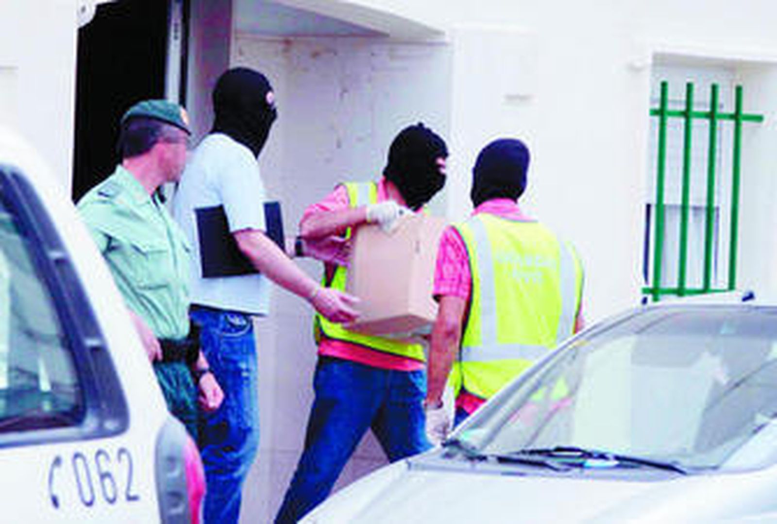 Efectivos de la Guardia Civil sacan material de la calle Almonte de Huelva, donde se realizaron dos detenciones.