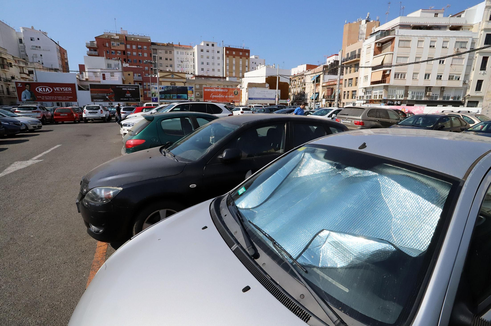 Un coche se protege del sol en el aparcamiento del antiguo mercado.