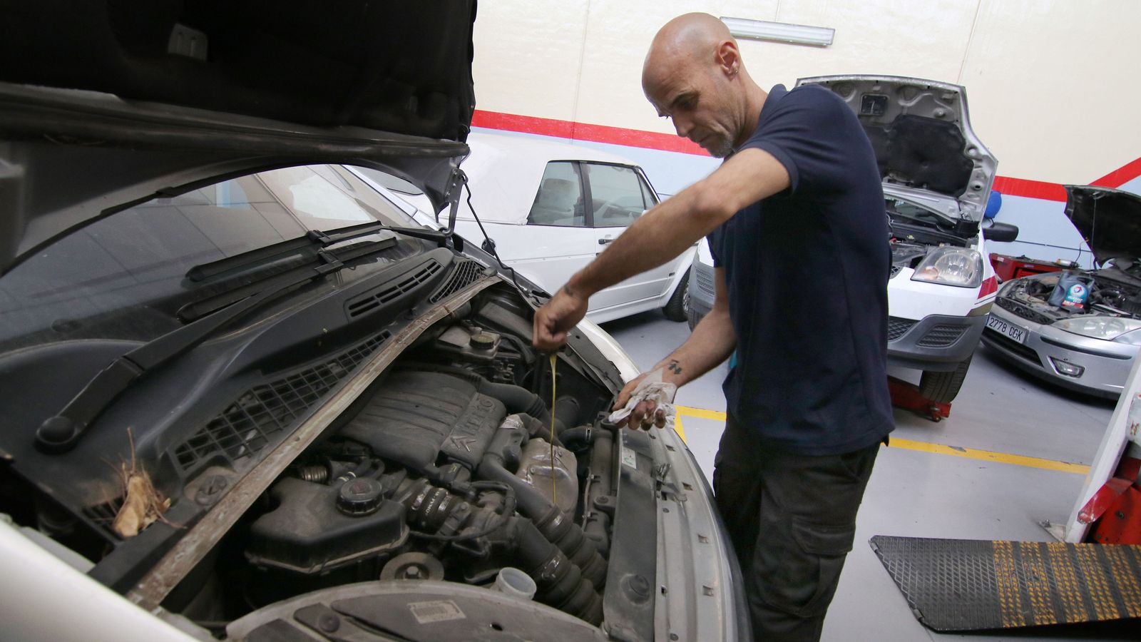 un técnico revisa el aceite de un vehículo.
