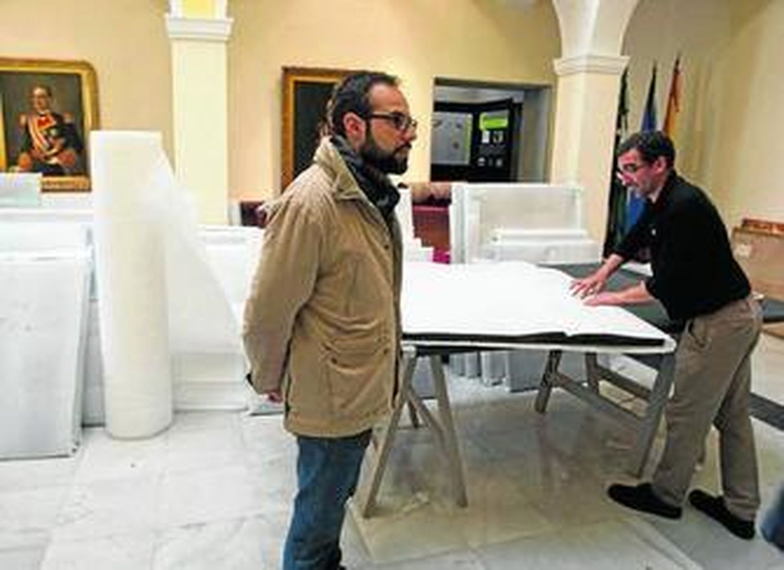 Uno de los operarios de la empresa encargada del traslado de las piezas, ayer, mientras acarrea varios lienzos debidamente embalados para la mundanza.