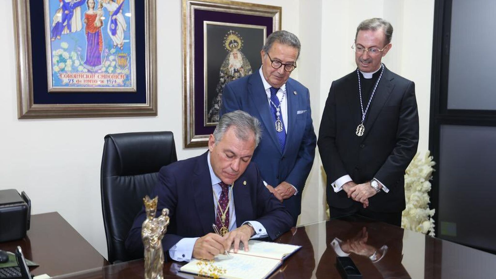 Sanz firmando en el libro de honor de la cofradía