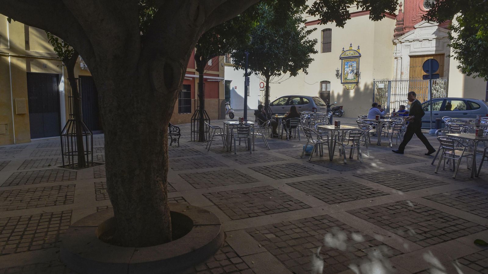La fachada de la parroquia entre los árboles de la Plazuela de Santa Ana