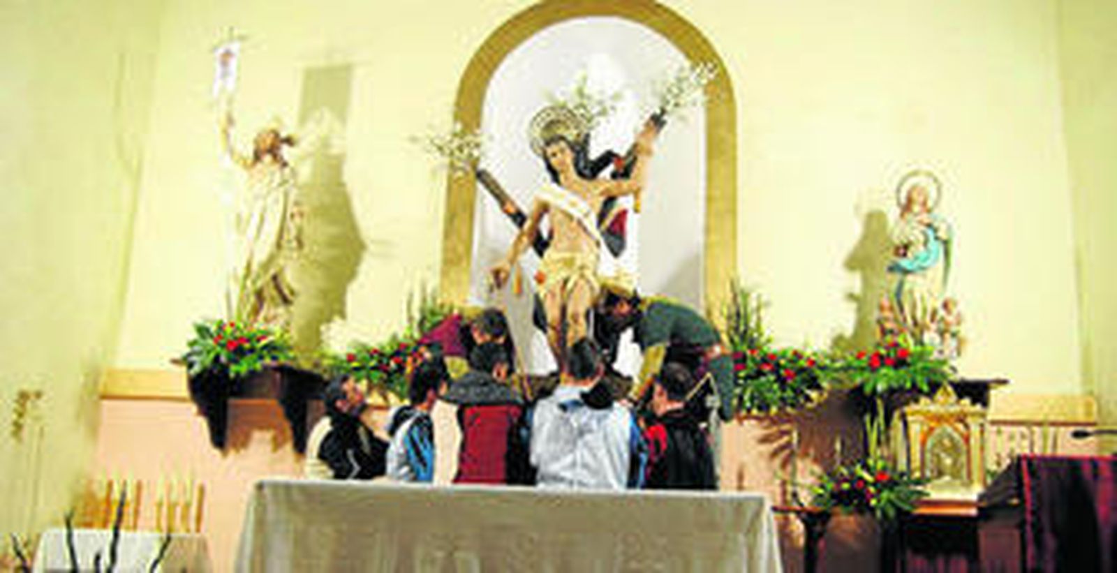 Miembros de las tropas mora y cristiana bajan al patrón de su hornacina que preside la ermita que lleva su nombre.