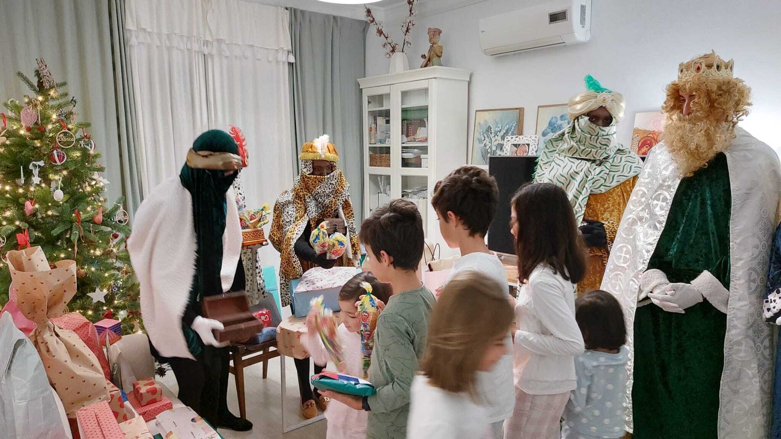 Los Reyes y sus pajes dejan regalos en una casa de Málaga.