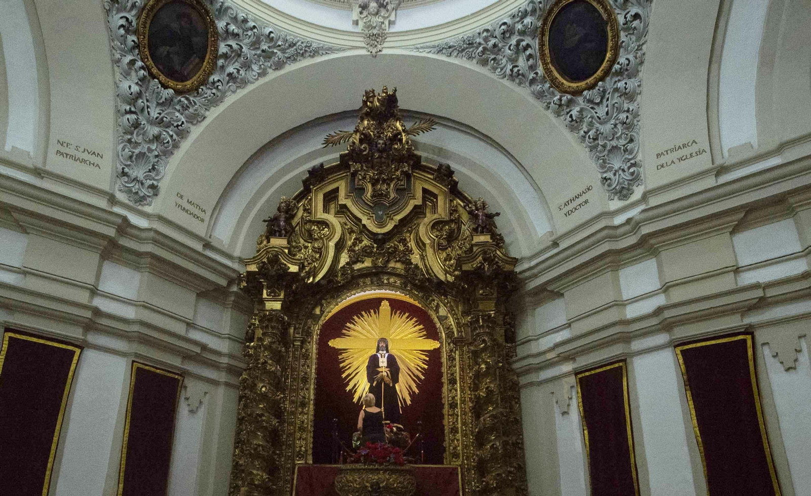 Una mujer retoca la imagen del Rescatado, en la iglesia de los Trinitarios Una mujer retoca la imagen del Rescatado, en la iglesia de los Trinitarios