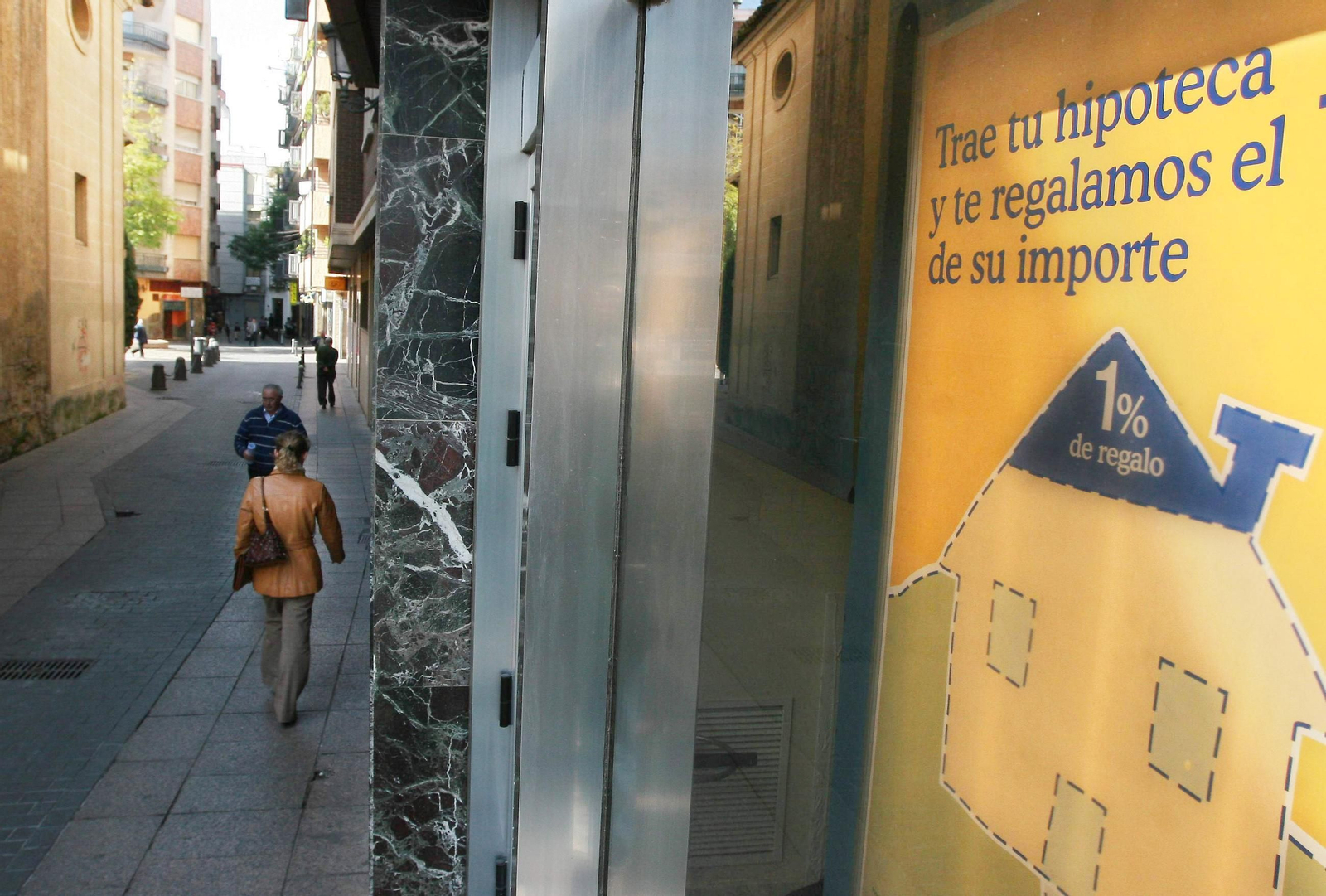 Fotos de escaparates de entidades financieras con carteles anunciando nuevas hipotecas .
