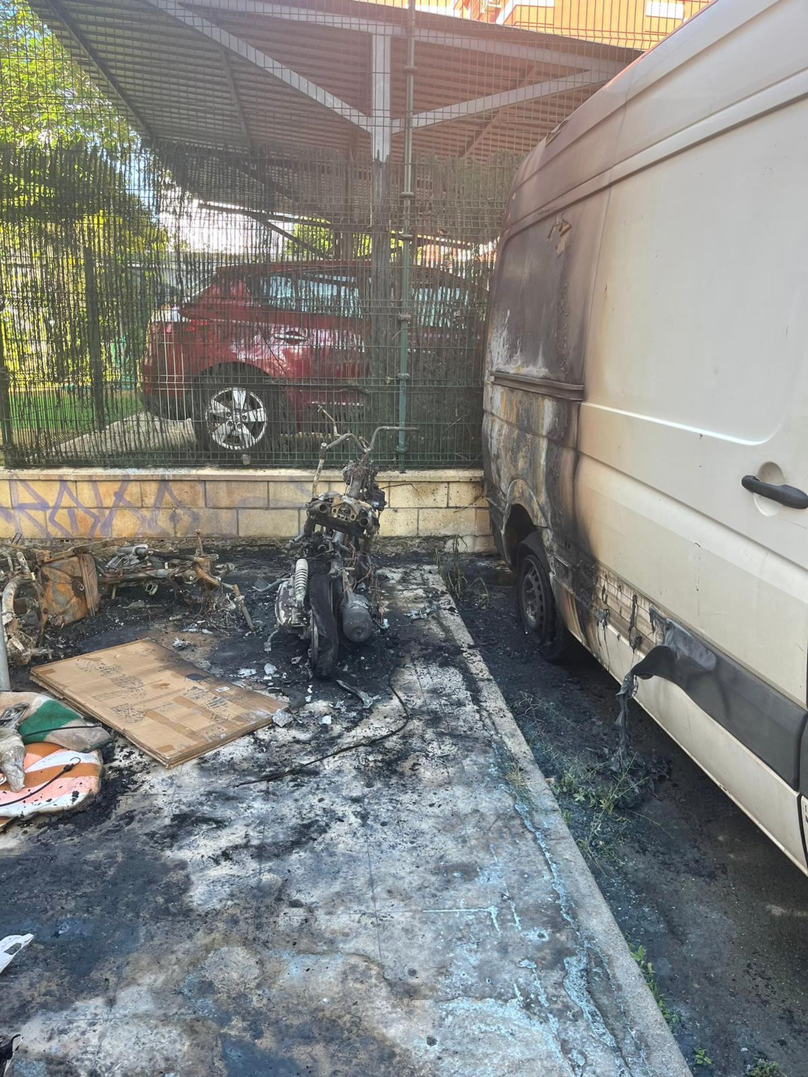 Una de las motos calcinadas, junto a una furgoneta afectada por las llamas.