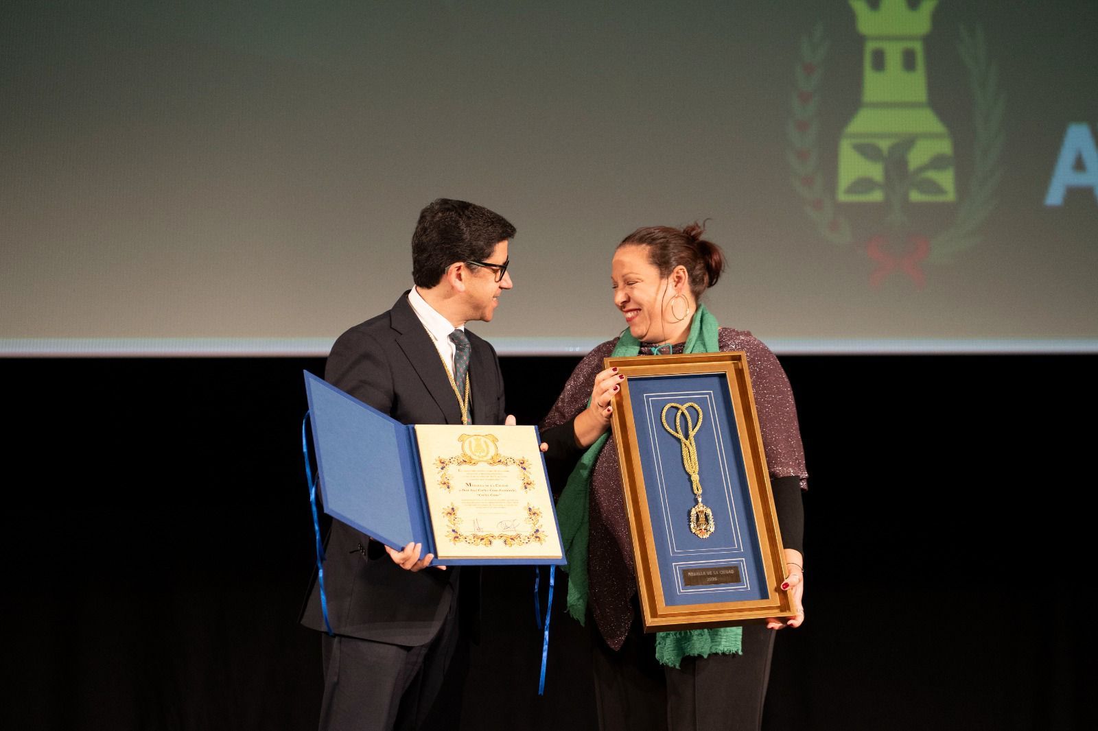 La hija de Carlos Cano, Paloma Cano, recogiendo el premio junto al alcalde del municipio Alberto Fernández.