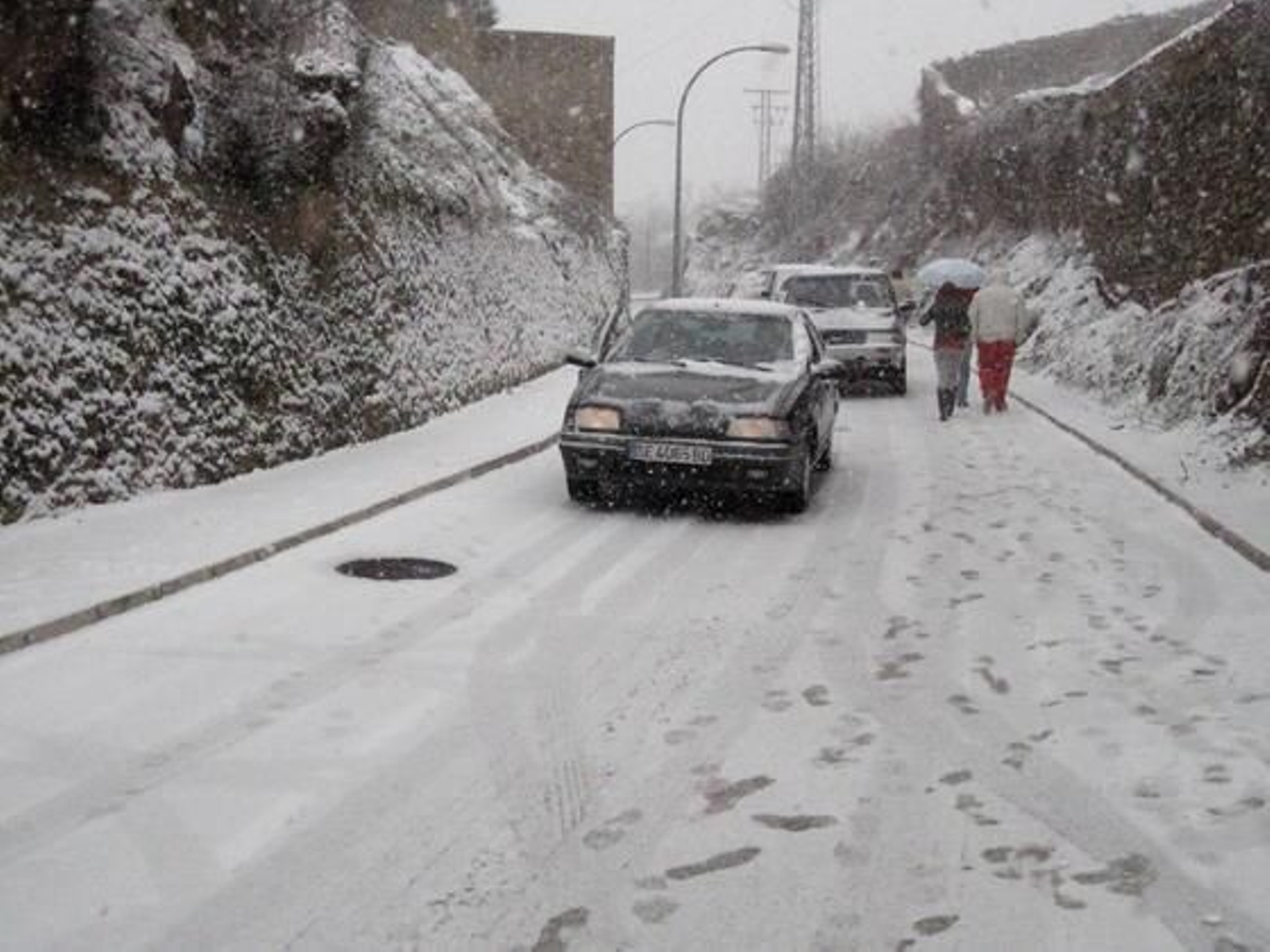 Los coches bajan lentamente una cuesta ante la acumulación de nieve en la calzada.

Foto: C. Valdivieso